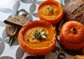 Creamy pumpkin soup and homemade bread on grey tiled table. Soup in a squash top view photo. Thanksgiving menu ideas.ÃÂ ÃÂ  Royalty Free Stock Photo